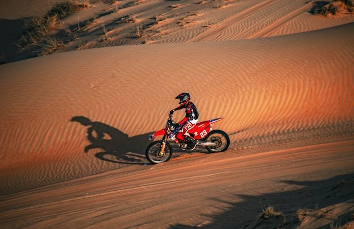 motorbike riding over sand dunes