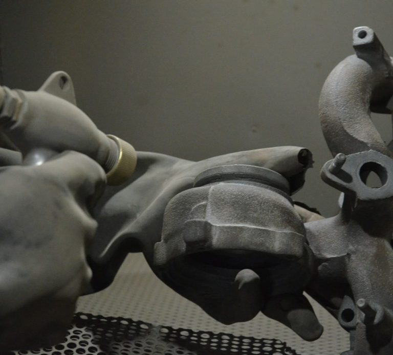 an engine part being dry blasted 
