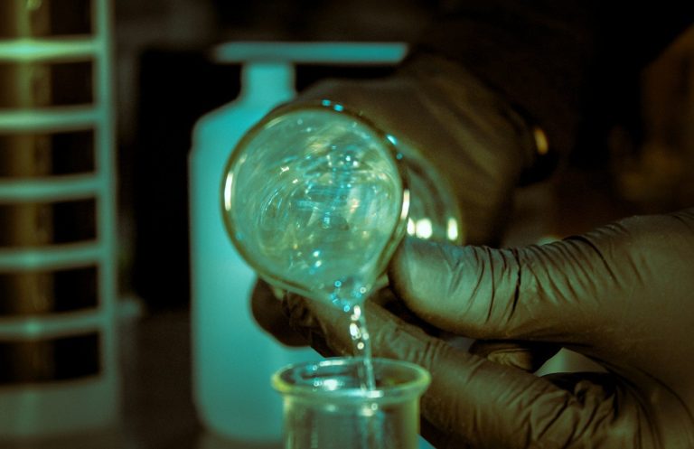 chemicals being poured from beaker